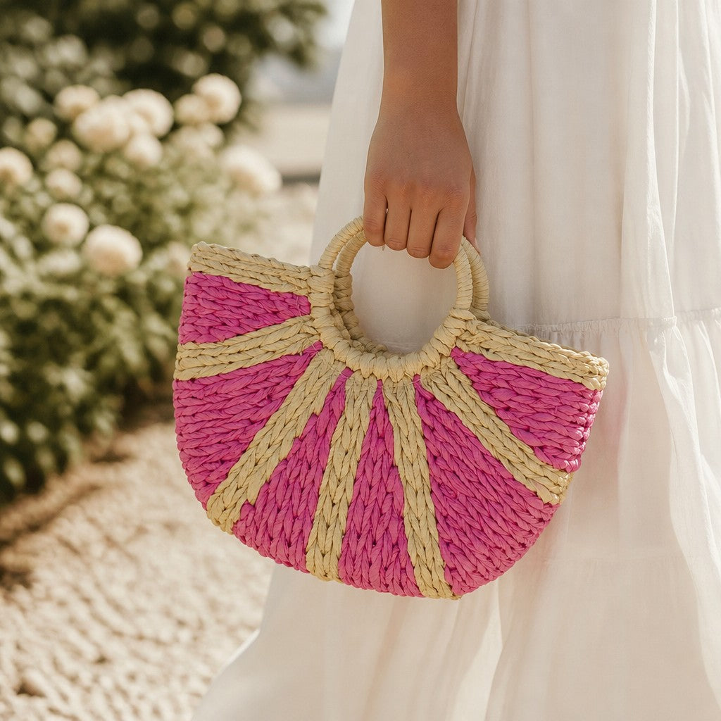 L and B Creations two-toned pink and straw wicker handbag with round handles held by a woman in a white dress