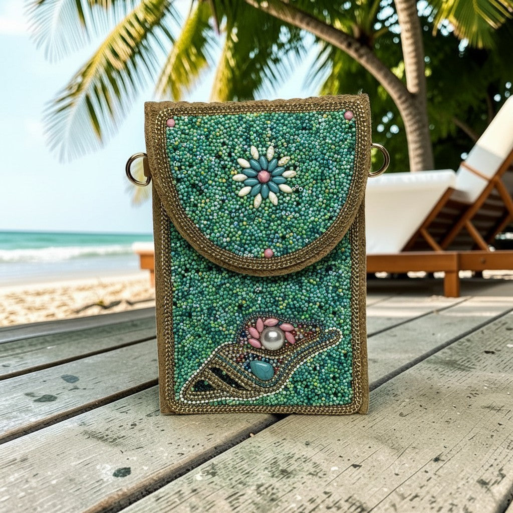L and B Creations tropical fold-over clutch with teal beadwork, floral and seashell motifs, and a crossbody strap.