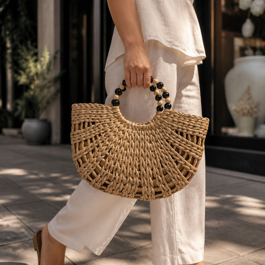 L and B Creations beige woven twine canvas handbag with a circular beaded handle held by a woman in white linen