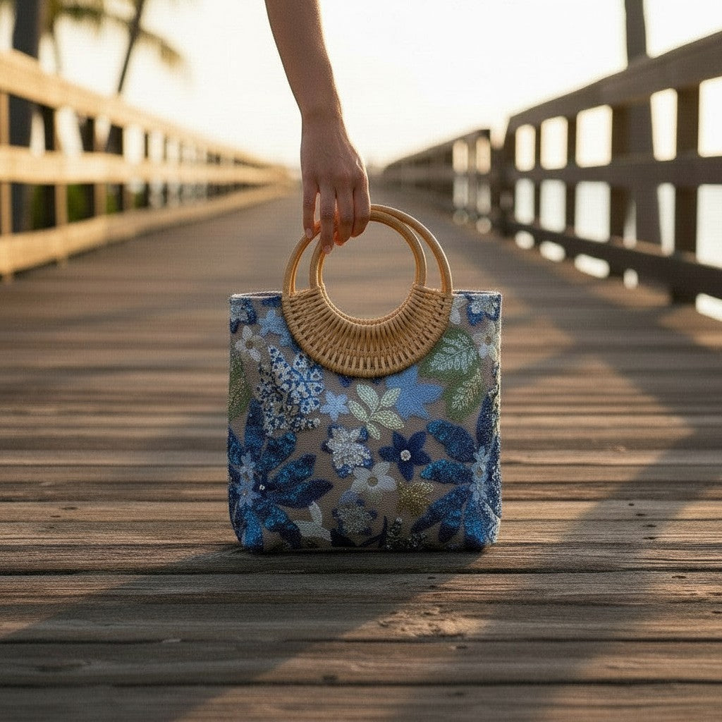 L and B Creations botanical embroidered sequin tote bag with round bamboo handles on a wooden pier