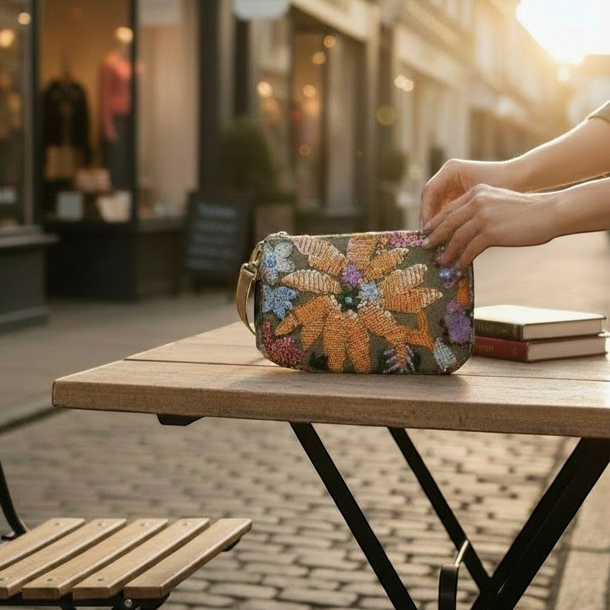 L and B Creations flower sequin purse with removable chain strap, held on an outdoor cafe table.