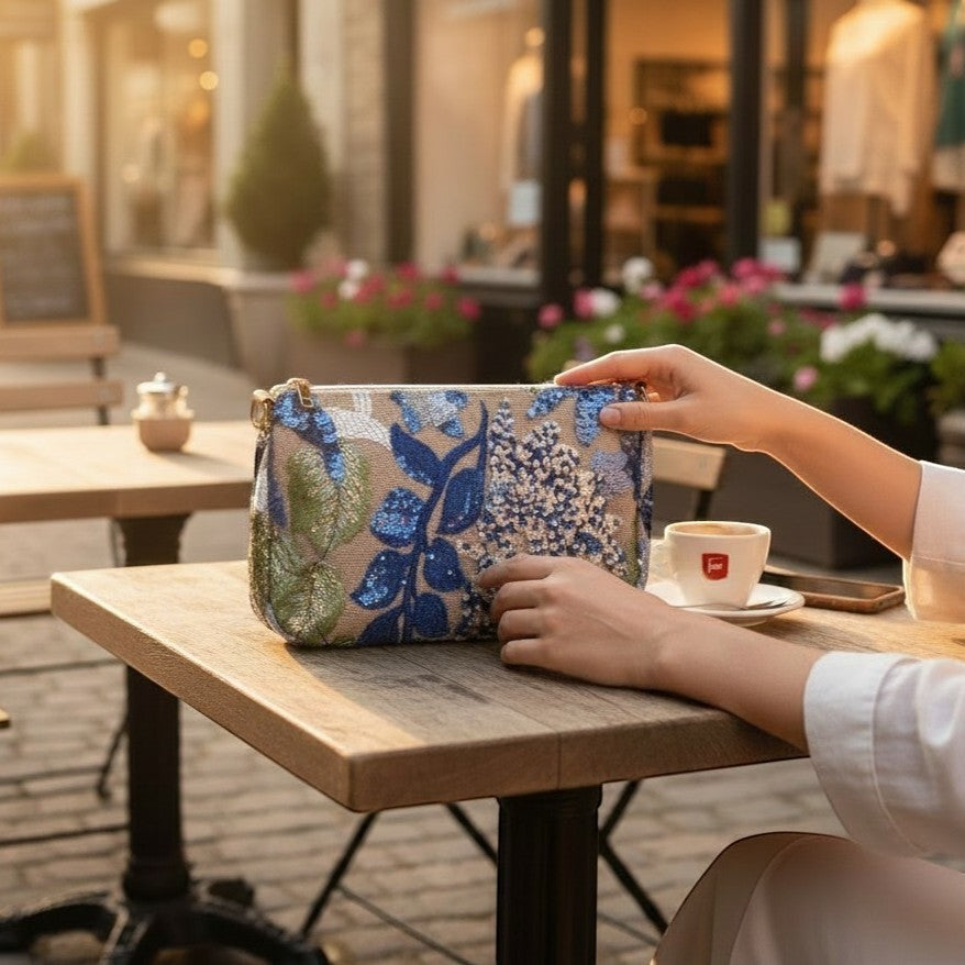 L and B Creations flower sequin purse with blue and green floral embroidery on a beige background at a cafe table