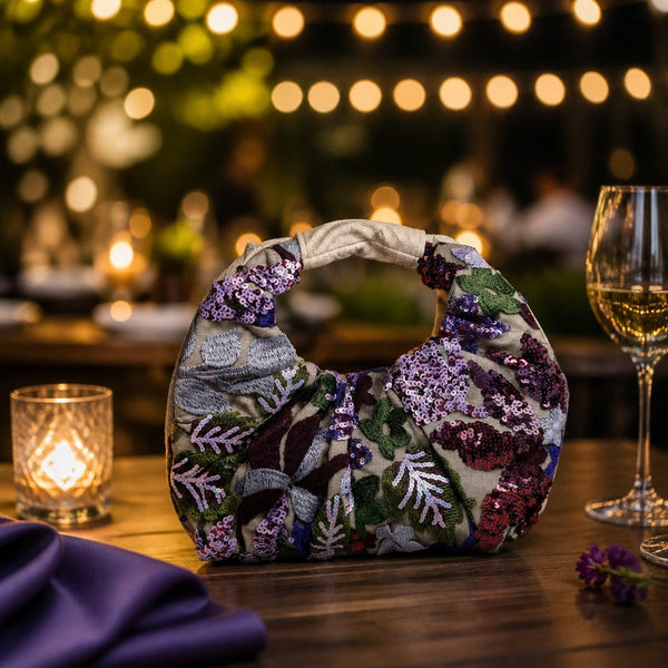 L and B Creations flower sequin scrunch handbag with cream interior and magnetic button closure on a wooden table.