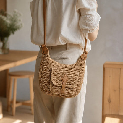 L and B Creations straw crossbody bag with adjustable leather strap and front square pocket worn by a woman